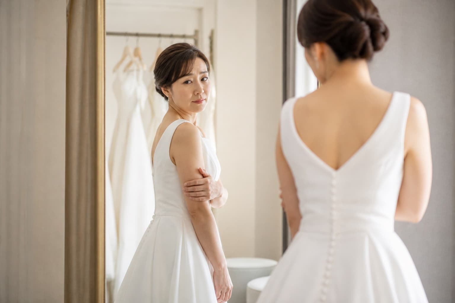 ドレス試着で鏡の前に立つ30代女性