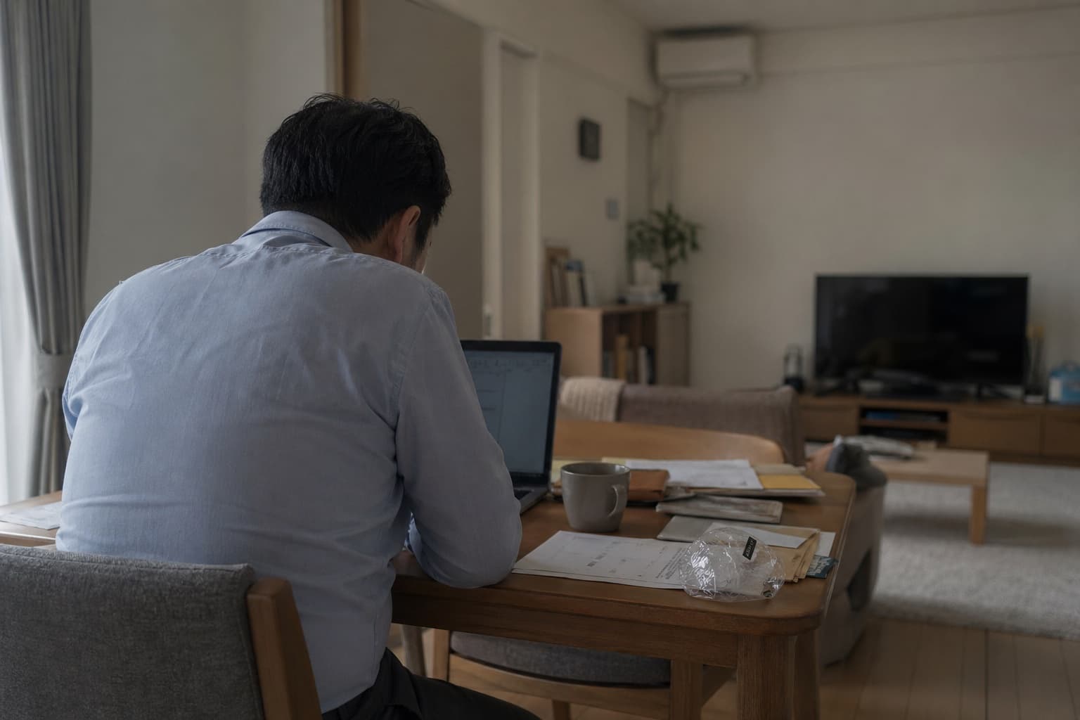 在宅で長時間デスクに向かう男性
